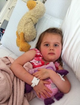 Allie in hospital bed with Duckie and Blankie.